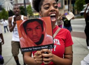 Averri Liggins, 22, of Atlanta, chants while holding a picture of Trayvon Martin