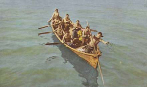 Eskimos hunting walrus in a skin omiak, or canoe. c 1920s postcard.