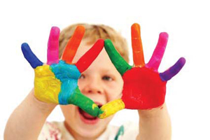 child with a rainbow of paint on his hands