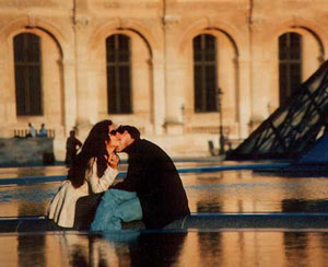 lovers kissing in front of the Louvre