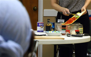 Student looks on as instructor Mandy Willig prepares food during &quot;A Taste of African Heritage&quot; class in Birmingham, Ala., on Tuesday, July 22, 2014. Aimed mainly at blacks but open to anyone, the classes are being held nationwide to encourage people to adopt traditional African cooking methods that include lots of fresh plant-based dishes.