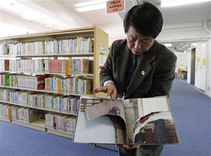 This ripped copy of Anne Frank's &quot;Diary of a Young Girl&quot; picture book is shown by Shinjuku City Library Director Kotaro Fujimaki at the library in Tokyo Friday, Feb. 21, 2014. A total of 265 books in 31 libraries had been found damaged after the first damaged book was found in January, prompting a wider search.