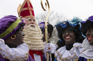 In this Nov. 16, 2013 file photo the Dutch version of Santa Claus, Sinterklaas, or Saint Nicholas, and his sidekicks known as &quot;Zwarte Piet&quot; or &quot;Black Pete&quot; arrive by steamboat in Hoorn, north-western Netherlands. A large majority of the Netherlands' mostly-white population say Pete is a positive figure and deny any racial insult. But a court and racism experts have found his appearance offensive.