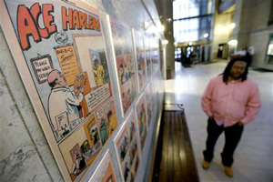In this Wednesday, Feb. 5, 2014 photo, Chay Tyler stands near the pages from the single issue of &quot;All-Negro Comics&quot; that is part of an exhibit on display at the City/County building in downtown Pittsburgh. The exhibit chronicles some early African American artists and a publisher who started to break the comic color barrier in the 1930s and 1940s. Tyler is a program coordinator for the city Department of Parks and Recreation and helped curate the exhibit.
