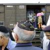 This Aug. 20, 2001, file photo shows French Holocaust survivors gathering at the site of the former Drancy detention camp, north of Paris, France. From Aug. 20, 1941 until the end of World War II, more than 70,000 Jewish men, women and children passed through Drancy on their way to Nazi extermination camps, particularly Auschwitz. The wagon is part of the memorial site.