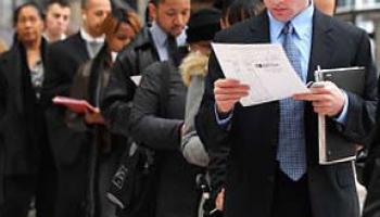 man reading paper while standing in line of people