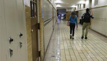 In this Monday, Jan. 13, 2014, file photo, two students walk in a hallway at Little Rock Central High School in Little Rock, Ark. Arkansas can stop making payments in one of the nation's most historic desegregation efforts, a judge has ruled, but he cautioned work remains to ensure students in the Little Rock area receive a proper education.