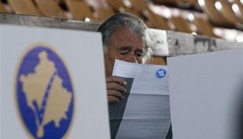 A Kosovo ethnic Albanian man looks at the ballot at a polling station in the Kosovo capital of Pristina before casting his vote Sunday, Nov 3, 2013. People in Kosovo are voting in a local election that will test the country's fragile relations with Serbia as both seek to move closer to the European Union. Serb participation in Kosovo's political life is a key element of an EU-brokered deal that seeks to settle the dispute over Kosovo and unlock EU funds.