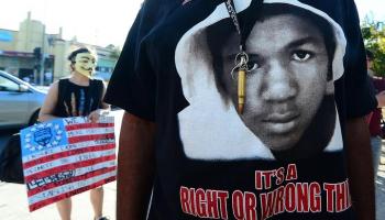 protests Trayvon Martin t-shirt and "Anonymous" mask