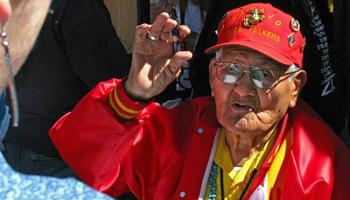 This Oct. 3, 2009, file photo, shows Navajo Code Talker Chester Nez speaking to a woman outside an Albuquerque, N.M., tourist shop during a book signing event for "Navajo Weapon." Nez, the last of the 29 Navajos who developed an unbreakable code that helped win World War II, died Wednesday morning, June 4, 2014, of kidney failure at his home in Albuquerque. He was 93.