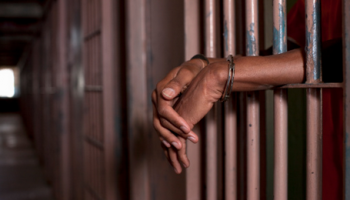 hands of an African-American man on cell bars