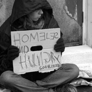 a homeless person holding a sign asking for help