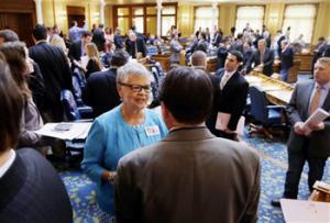 In this May 22, 2014 photo, New Jersey Assemblywoman and congressional candidate, Bonnie Watson Coleman, center, D-Trenton, N.J., stands on the floor of the assembly before a session at the Statehouse in Trenton, N.J. More than 100 black candidates will be on the ballot in statewide and congressional races next month, a post-Reconstruction record that some observers say is a byproduct of President Barack Obama’s historic presidency.