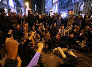 A group of protesters rallying against a grand jury's decision not to indict the police officer involved in the death of Eric Garner stage a brief sit in at the corner of Broadway and Prince Street, Wednesday, Dec. 3, 2014, in New York.