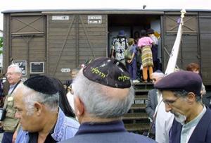 This Aug. 20, 2001, file photo shows French Holocaust survivors gathering at the site of the former Drancy detention camp, north of Paris, France. From Aug. 20, 1941 until the end of World War II, more than 70,000 Jewish men, women and children passed through Drancy on their way to Nazi extermination camps, particularly Auschwitz. The wagon is part of the memorial site.