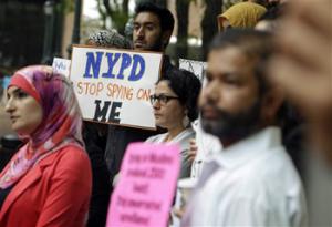 In this Aug. 28, 2013, file photo, a group of people hold signs protesting the New York Police Department’s program of infiltrating and informing on Muslim communities during a rally near police headquarters in New York. On Tuesday, April 15, 2014, the NYPD confirmed it disbanded the special intelligence unit that monitored Muslim communities in New York and New Jersey.