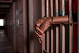 hands of an African-American man on cell bars