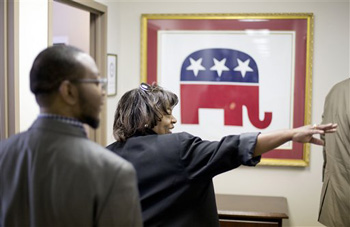 This photo taken May 19, 2014, shows former Republican candidate for Congress, Vivian Childs, right, walking through the Georgia GOP headquarters, followed by Michael Roundtree, chairman of the Morehouse College Republicans, before a training session with Leo Smith, minority engagement director for the Georgia Republican Party, not shown, in Atlanta.