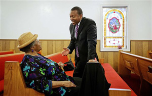 In this photo taken May 18, 2014, Leo Smith, right, minority engagement director for the Georgia Republican Party, talks with parishioner Annie Mae Dukes following a service for the 137th anniversary of Mount Zion First Baptist Church in Smyrna, Ga. Smith is on the GOP's front lines recruiting African-American voters in pivotal states.