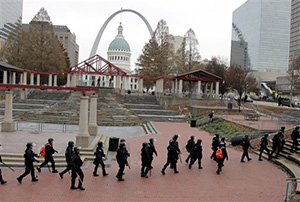 Officers wearing riot gear walk through a park Sunday, Nov. 30, 2014, in downtown St. Louis. Police and protesters clashed after an NFL football game between the St. Louis Rams and the Oakland Raiders as protests continued following a grand jury's decision not to indict a Ferguson police officer in the shooting death of Michael Brown.