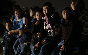 This June 25, 2014, file photo shows a group of immigrants from Honduras and El Salvador who crossed the U.S.-Mexico border illegally are stopped in Granjeno, Texas.