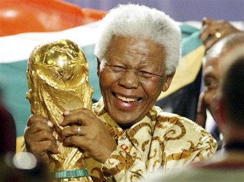 In this May 15, 2004 file photo, former South African President Nelson Mandela lifts the World Cup trophy in Zurich, Switzerland, after FIFA's executive committee announced that South Africa would host the 2010 FIFA World Cup soccer tournament. Mandela was pivotal in helping the country win the right to host the tournament. South Africa's President Jacob Zuma said, Thursday, Dec. 5, 2013, that Mandela has died. He was 95.