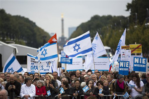 People with Israeli flags and banners, reading &quot;never again&quot; attend a rally against anti-Semitism near the Brandenburg Gate in Berlin, Sunday, Sept. 14, 2014. Thousands of protesters attended the public rally Gate after tensions over the Gaza conflict spilled over into demonstrations in Europe that saw anti-Jewish slogans and violence.
