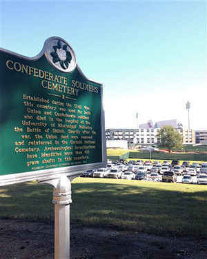 In this Oct. 21, 2014, photo, a state historical sign marks the Confederate Soldiers Cemetery on the University of Mississippi campus in Oxford, Miss. The cemetery sits across a ridge from the stadium where the Ole Miss Rebels are enjoying their best football season in more than 50 years. The university’s chancellor, Dan Jones, released a diversity report in August, the latest effort to distance the state’s flagship academic institution from its segregationist history.