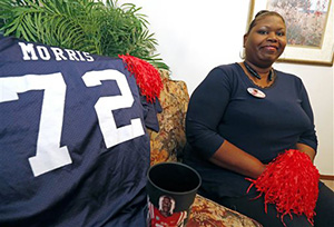 In this photo taken on Thursday, Oct. 16, 2014, lifelong Mississippi resident Logenvia Morris poses at her home in Jackson, Miss., next to her prize possession, the first Mississippi game jersey her son Aaron Morris wore for the football team. The warm welcome extended to both mother and son during a recruiting visit by students and players are among the main reasons the Morris family were quick to join the Ole Miss family.