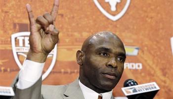 Charlie Strong holds up the "Hook'em Horns" hand signal during an NCAA college football news conference where he was introduced as the new Texas football coach, Monday, Jan. 6, 2014, in Austin, Texas. Strong acknowledged the historical significance of being the school's first African-American head coach of a men's sport. He takes over for Mack Brown, who stepped down last month after 16 seasons.