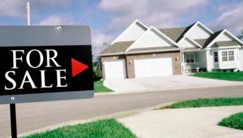 "For Sale" sign in front of a house