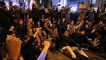 A group of protesters rallying against a grand jury's decision not to indict the police officer involved in the death of Eric Garner stage a brief sit in at the corner of Broadway and Prince Street, Wednesday, Dec. 3, 2014, in New York.