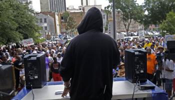 Rev. Dr. Norwood Thompson - wearing a hoodie - speaks to a crowd of protesters