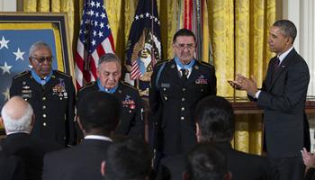 President Barack Obama applauds, from left, Staff Sgt. Melvin Morris, Sgt. 1st Class Jose Rodela, and Spc. Santiago J. Erevia after he awarded them with the Medal of Honor during a ceremony in the East Room of the White House in Washington, Tuesday, March 18, 2014.