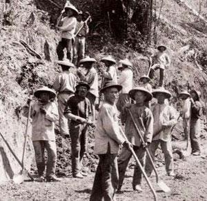 Chinese immigrant laborers use shovels to build a railroad