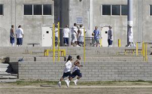 In this 2013 file photo, inmates work out in the exercise yard of Housing Unit B at California State Prison Sacramento, near Folsom, Calif. California prison officials on Wednesday Oct. 22, 2014, agreed to end a policy in which it segregated prison inmates after riots based on their race as a way to prevent further violence.