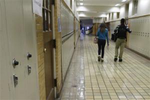 In this Monday, Jan. 13, 2014, file photo, two students walk in a hallway at Little Rock Central High School in Little Rock, Ark. Arkansas can stop making payments in one of the nation's most historic desegregation efforts, a judge has ruled, but he cautioned work remains to ensure students in the Little Rock area receive a proper education.