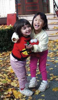 Two Asian-American girls smiling and playing