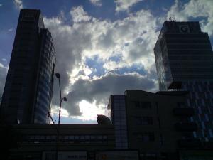 sunshine and clouds rising above buildings