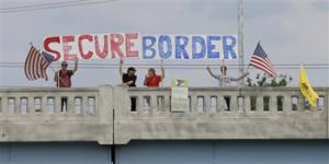 This July 18, 2014, file photo shows demonstrators with signs on an overpass in Indianapolis, to protest against people who immigrate illegally.