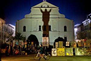 In this Friday, Feb. 1, 2013 file photo, a pedestrian walks her bicycle past a silhouette of Jesus Christ projected against the Cathedral-Basilica of Saint Louis King of France in New Orleans, two days ahead of the NFL Super Bowl football game between the San Francisco 49ers and the Baltimore Ravens. "I find it fascinating that that's what people really want to know -- what race was Jesus.