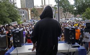 Rev. Dr. Norwood Thompson - wearing a hoodie - speaks to a crowd of protesters