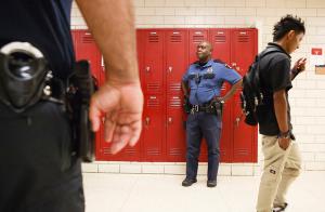 police officers and a adolescent student in a school corridor