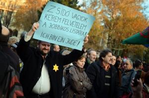 demonstrator holds a placard as he wears a yellow star